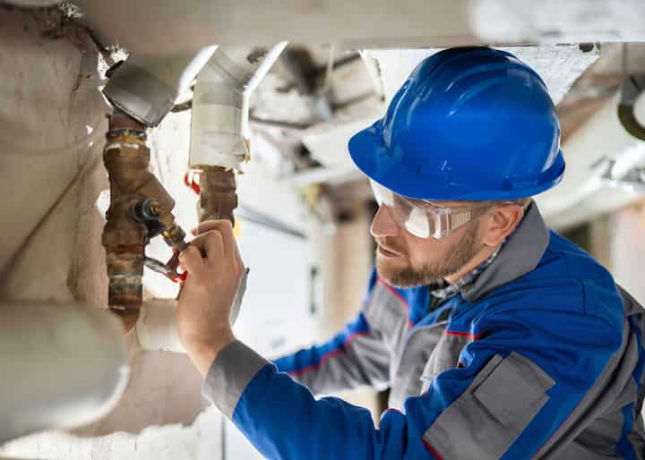 Expert in blue hard hat handling water damage repair in Rome, Georgia.